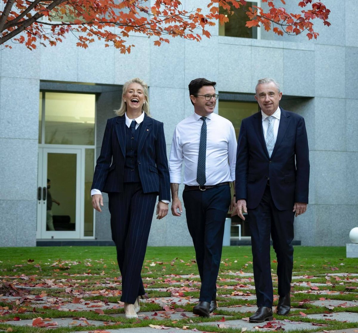woman and two men in parliament house courtyard