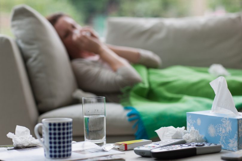 Woman lying on lounge with flu
