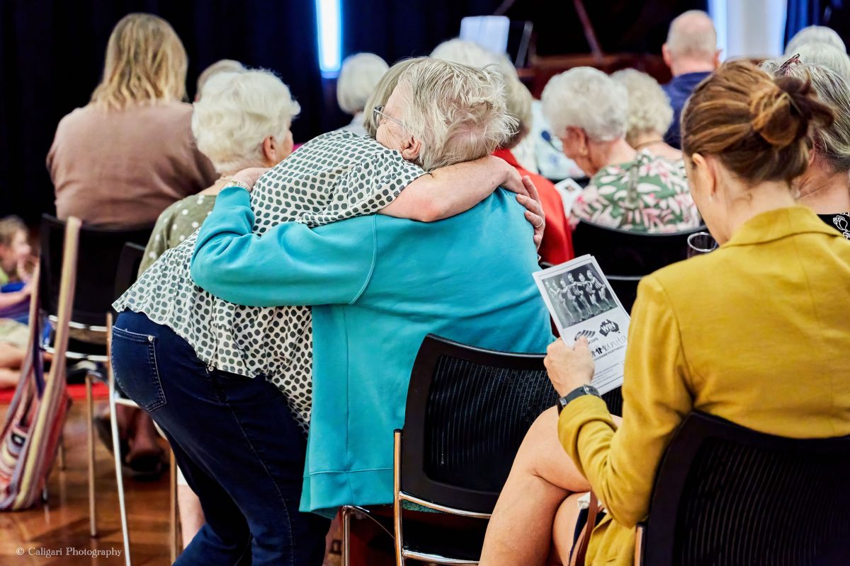 Two women embrace 