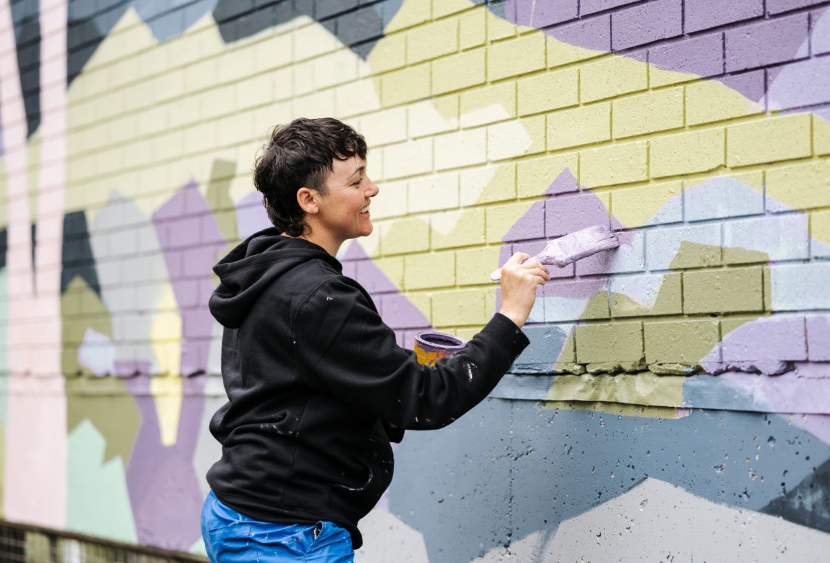 Woman painting a building