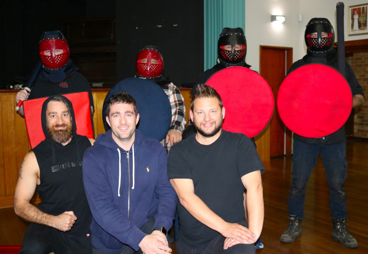 Group of men holding shields with masks on.