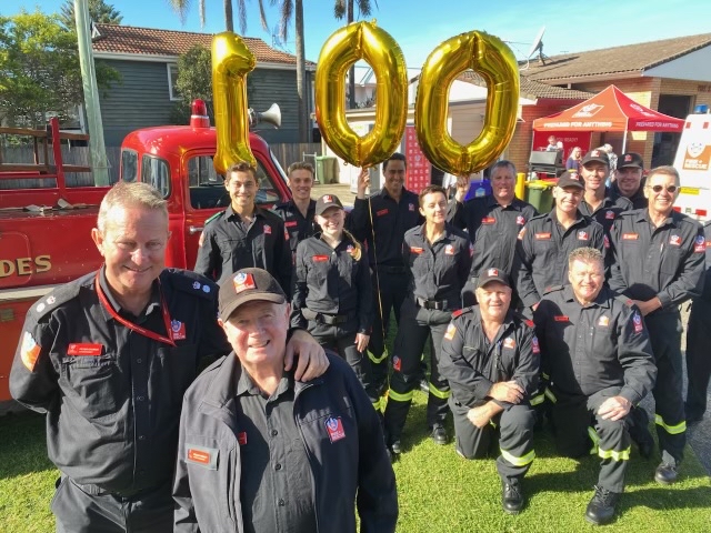 Crew at Thirroul Fire Station with gold balloons spelling 100