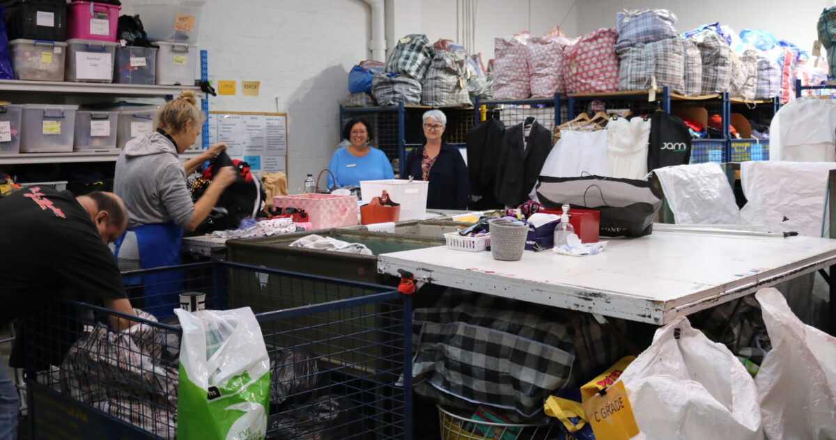 shop staff in clothes sorting area
