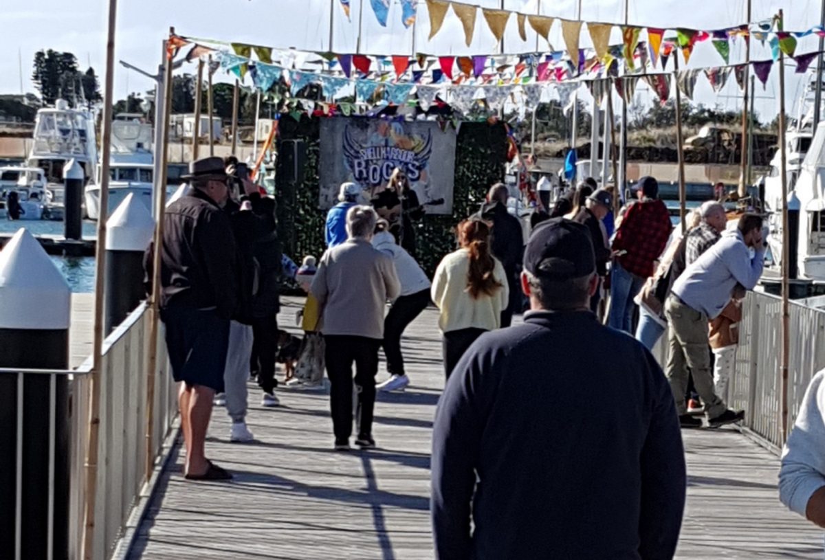 People walk the boardwalk at Shellharbour marina