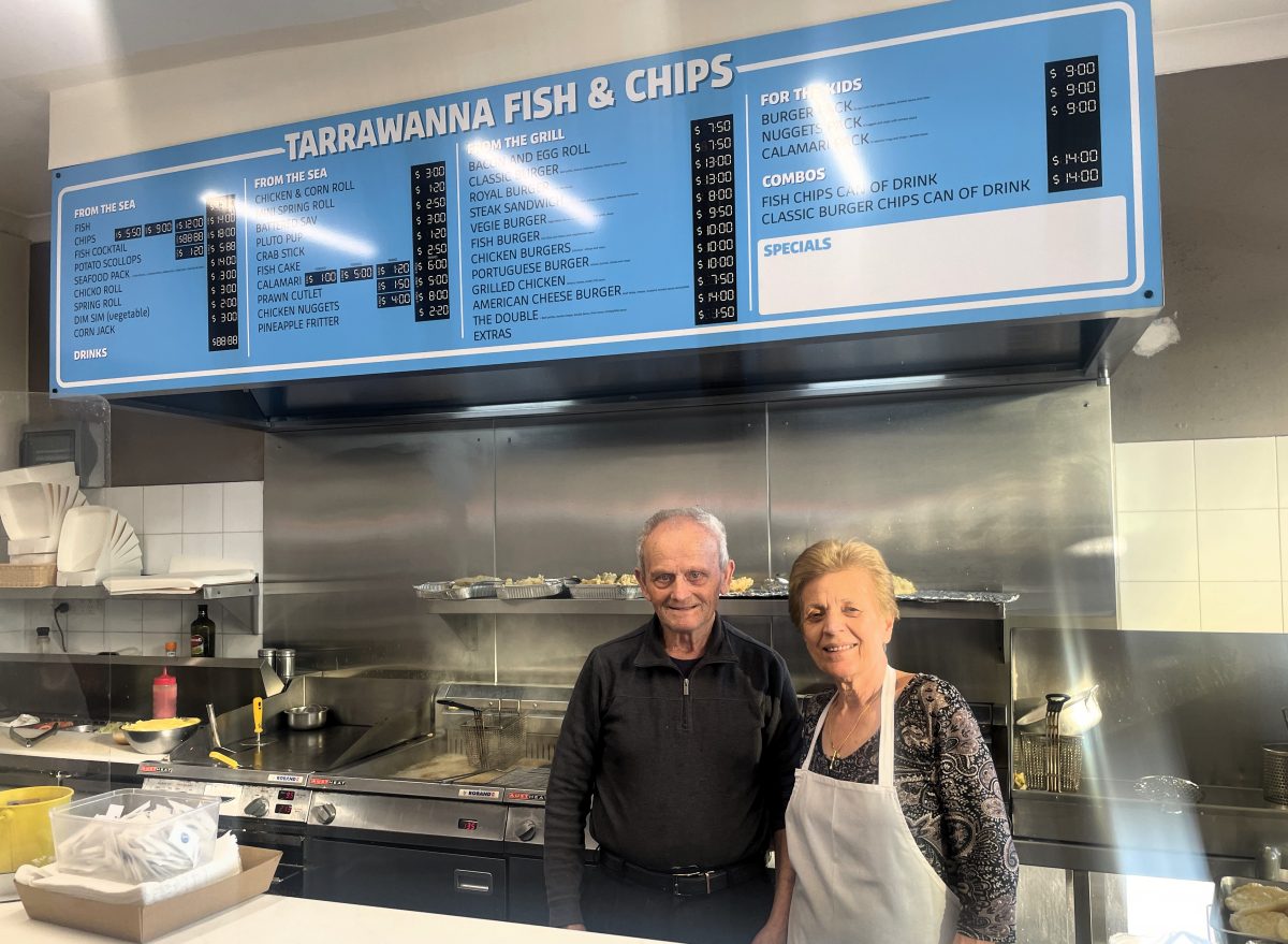 Jimmy and Vera Mitrevski in front of menu sign at Tarrawanna Fish and Chips.