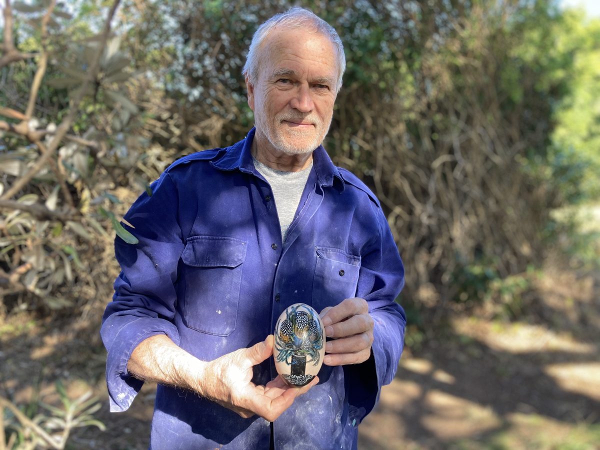 Stanwell Park sculptor Kieran Tapsell holds a hand painted ceramic egg