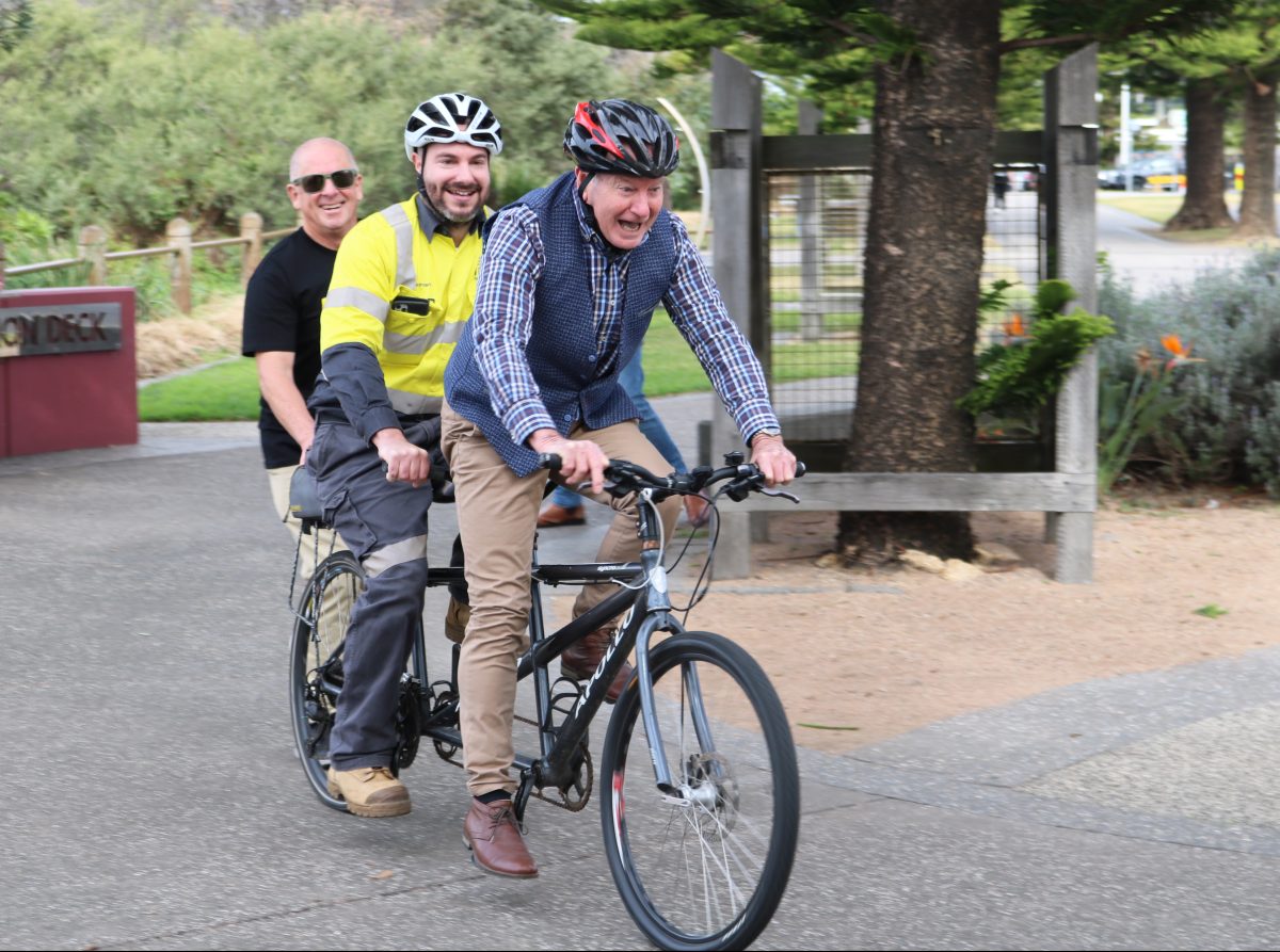Mayor Gordon Bradbery and South 32's Antony Leone get a helping hand riding a tandem bike.