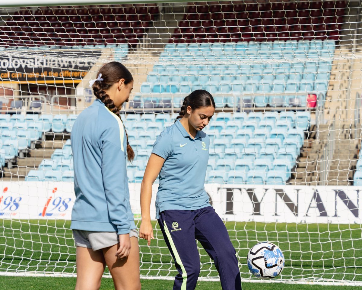 Kyani and Jynaya Dos Santos kicking a soccer ball.
