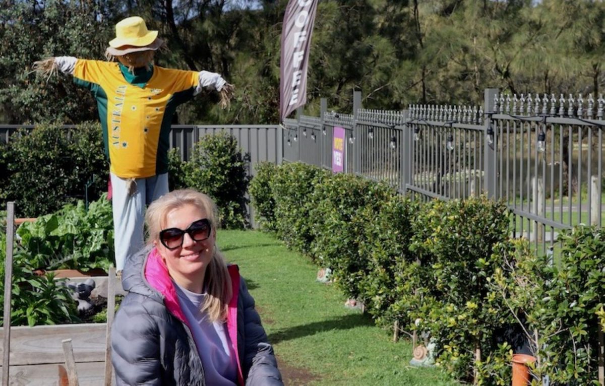 Lena Zakharova with her community garden scarecrow dressed to support the Matildas.