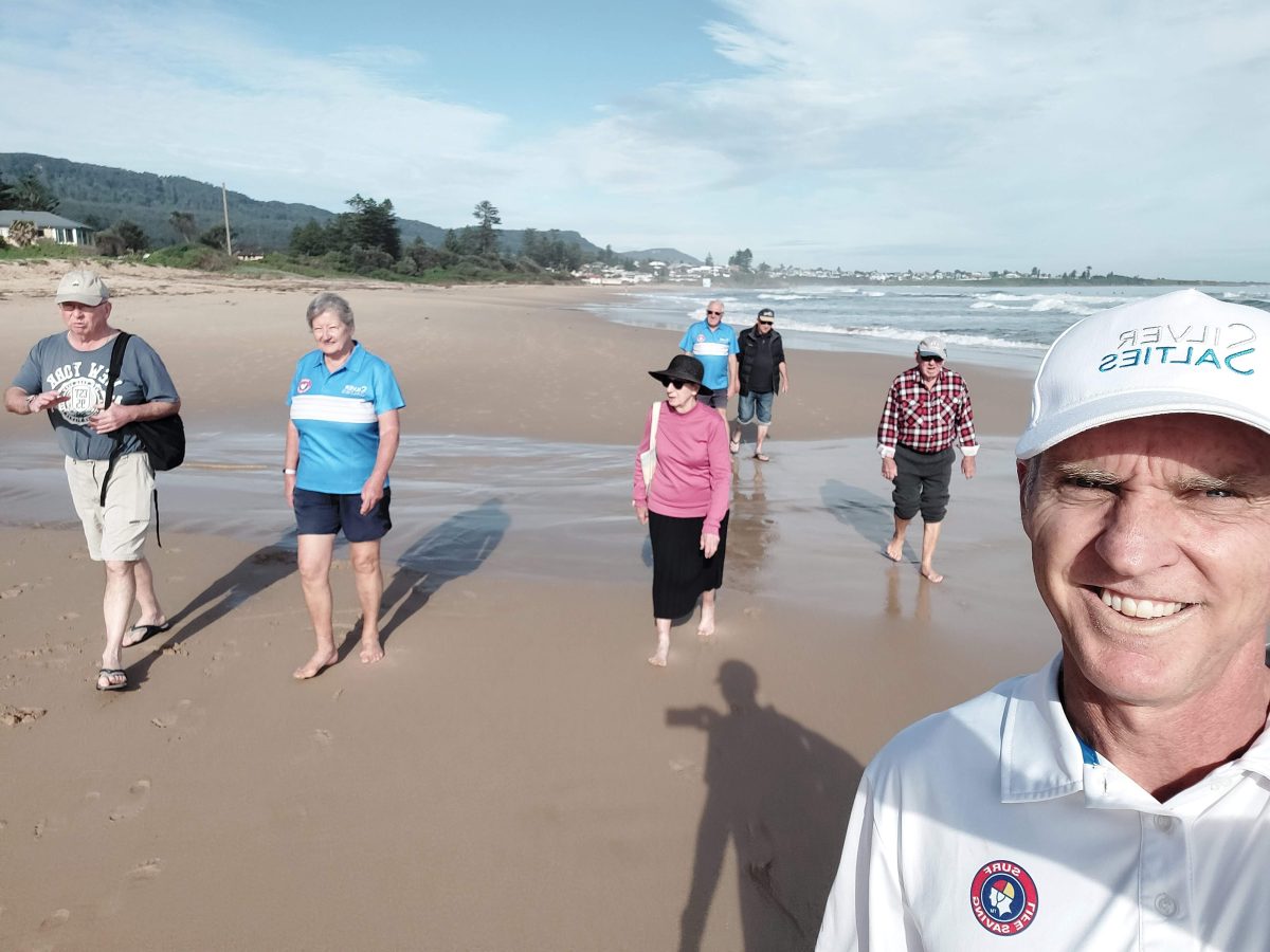 Ian Sakoff taking photo with walkers on beach