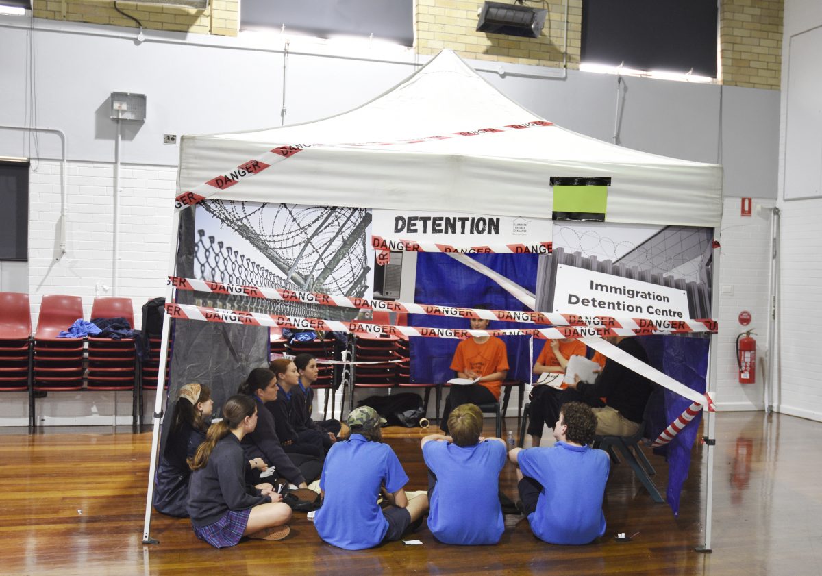 Bulli High School students sit in a tent marked Detention for the Illawarra Refugee Challenge