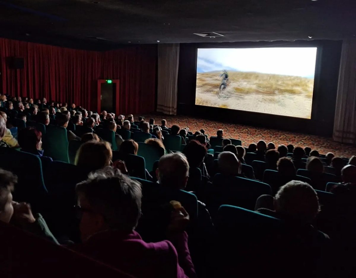 Audience in cinema watches biking documentary