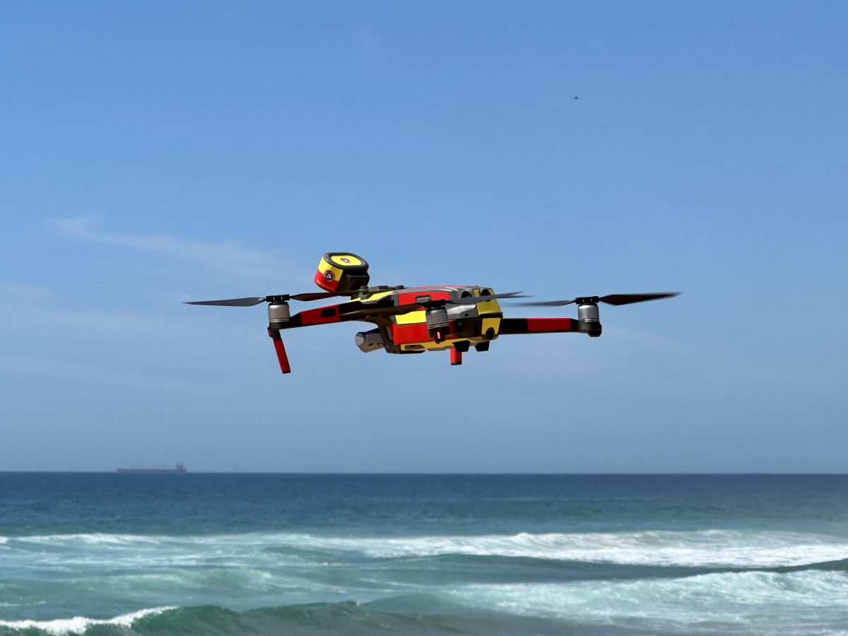 Surf Life Saving drone in the air at beach.