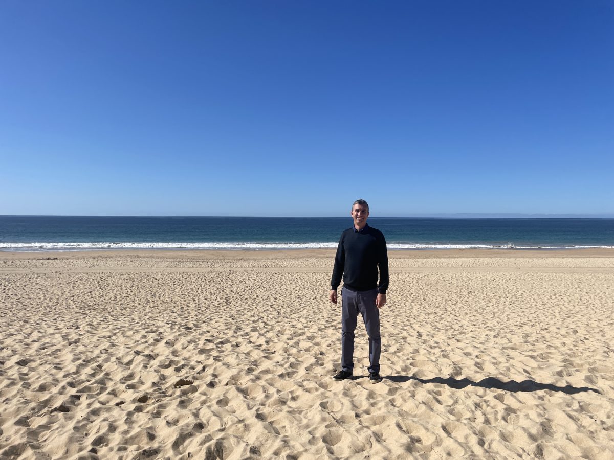 Associate Professor Michael Mehmet on a beach.
