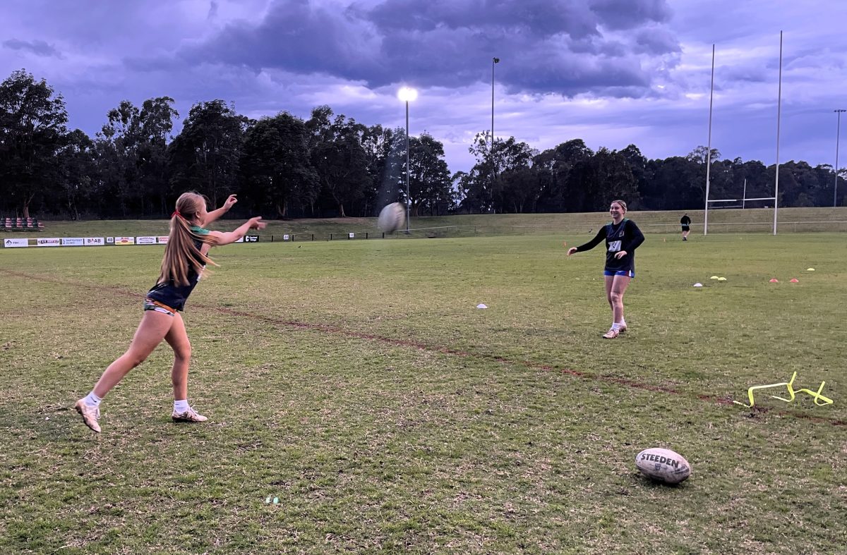 Matilda Powell and Skye Spencer throwing a ball to each other at Corrimal. 