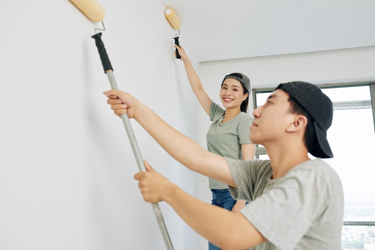 professional man and woman painting wall