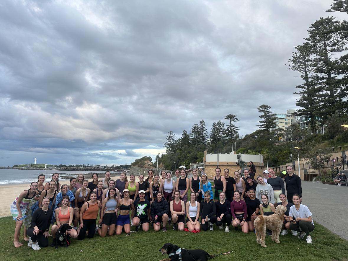 Good Energy Run Club assemble on the grass at North Wollongong Beach