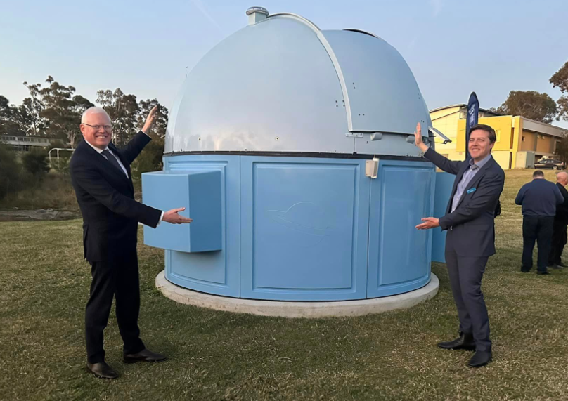 two men posing at an observatory