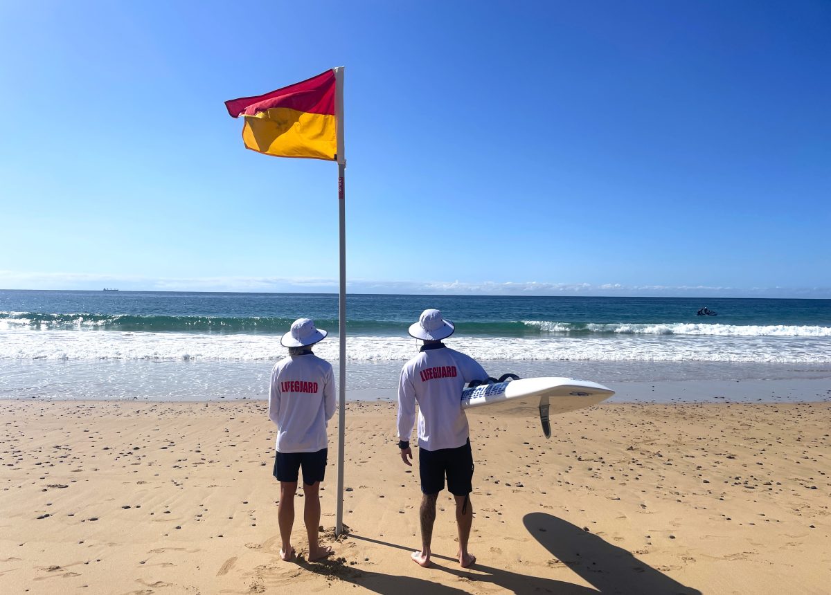 Wollongong City Lifeguards at North Wollongong Beach looking into the surf.