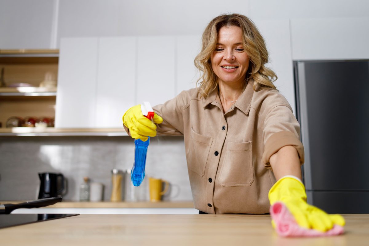 Woman cleaning kitchen countertop 