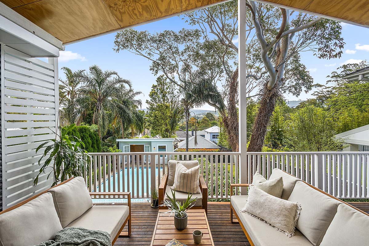 Covered deck at 8 Byrarong Avenue in Mangerton overlooks a pool, cabana and views to the Illawarra escarpment