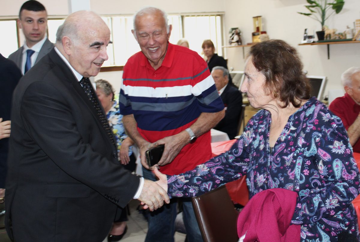 President of Malta George Vella shaking hands with community members. 