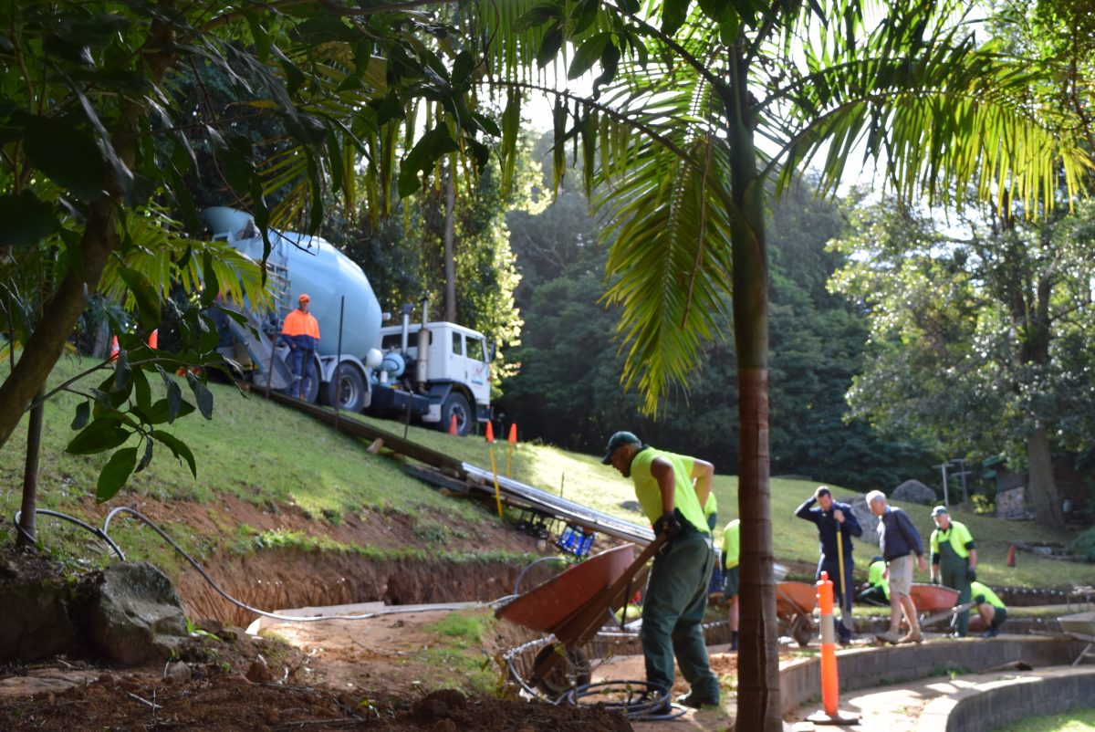 A cement truck and men working on a path