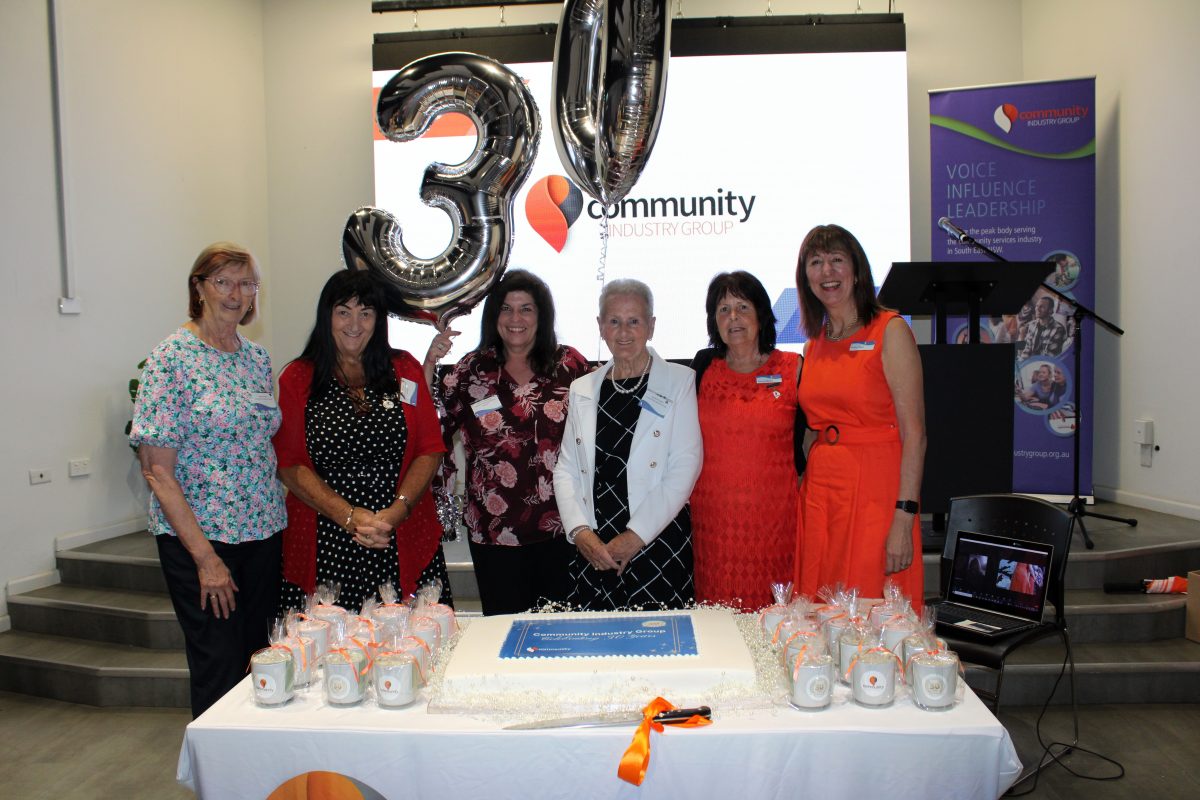 women at cake-cutting ceremony for community group
