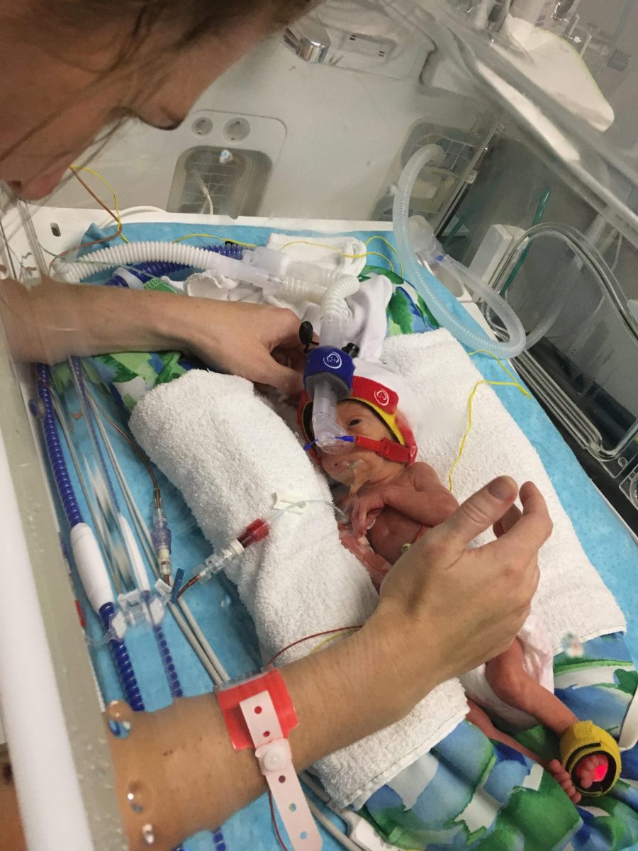 Ollie in NICU with hands.
