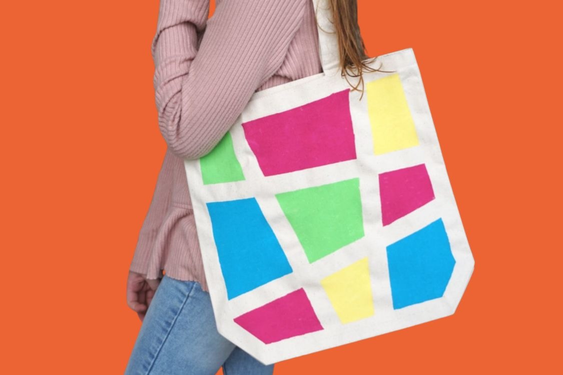 Person carrying calico tote bag with colourful geometric design
