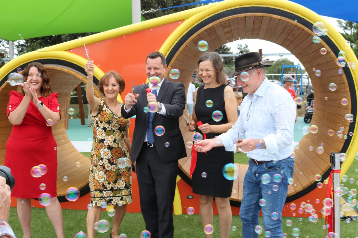 Five people surrounded by bubbles at the opening of the new playground.