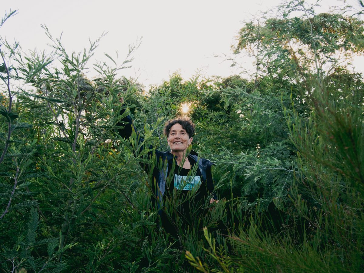 Edwina Robinson stands in a tangle of thriving native shrubs and saplings.