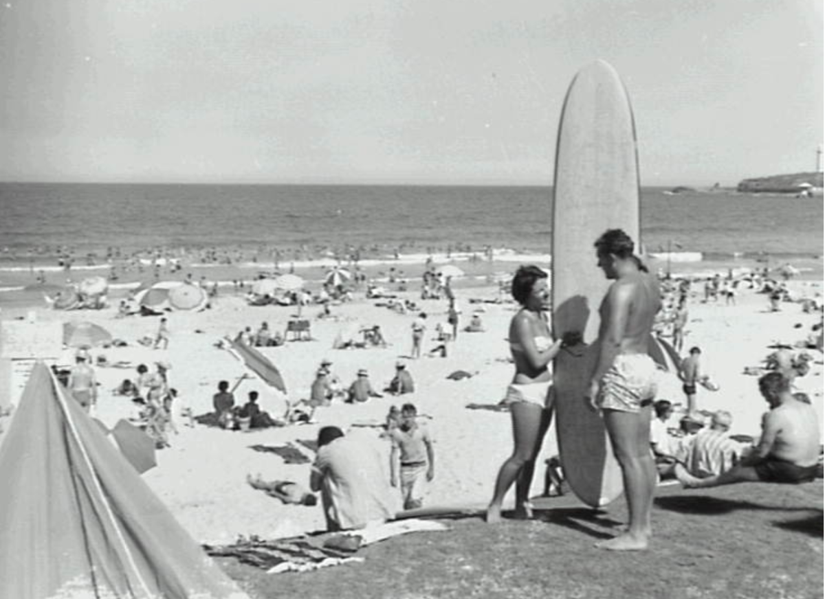 A couple with a longboard at North Wollongong Beach in 1956.