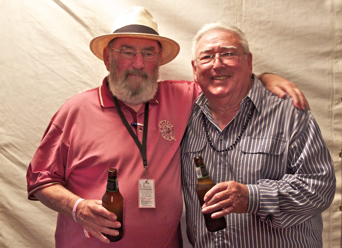 Russell Hannah and Ted Egan holding drinks.