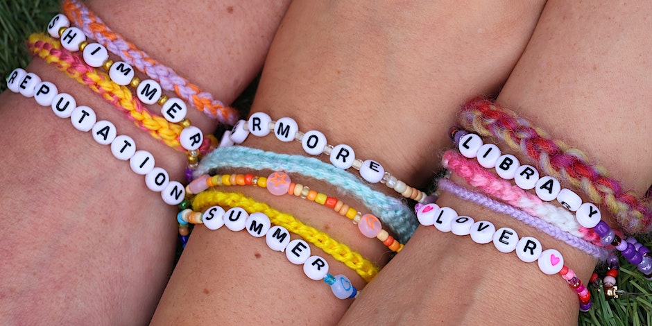 Three arms side by side wearing friendship bracelets