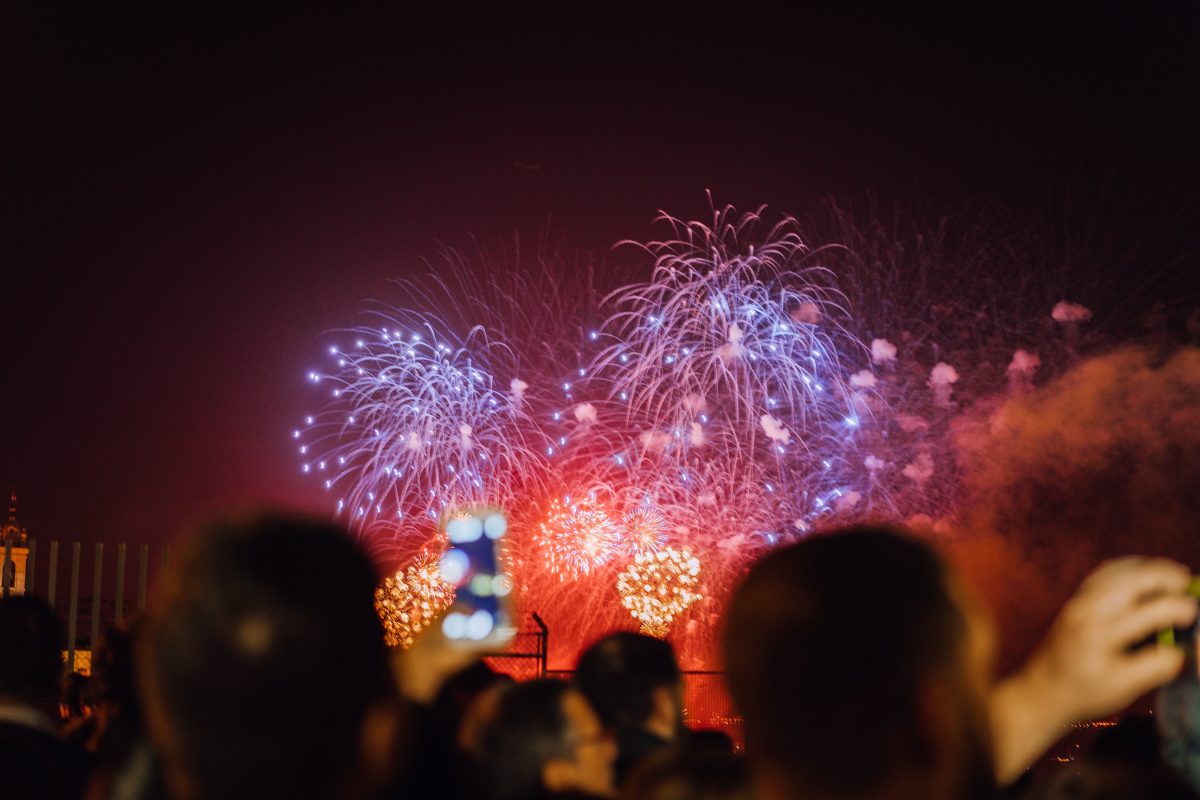 People in silhouette watch fireworks