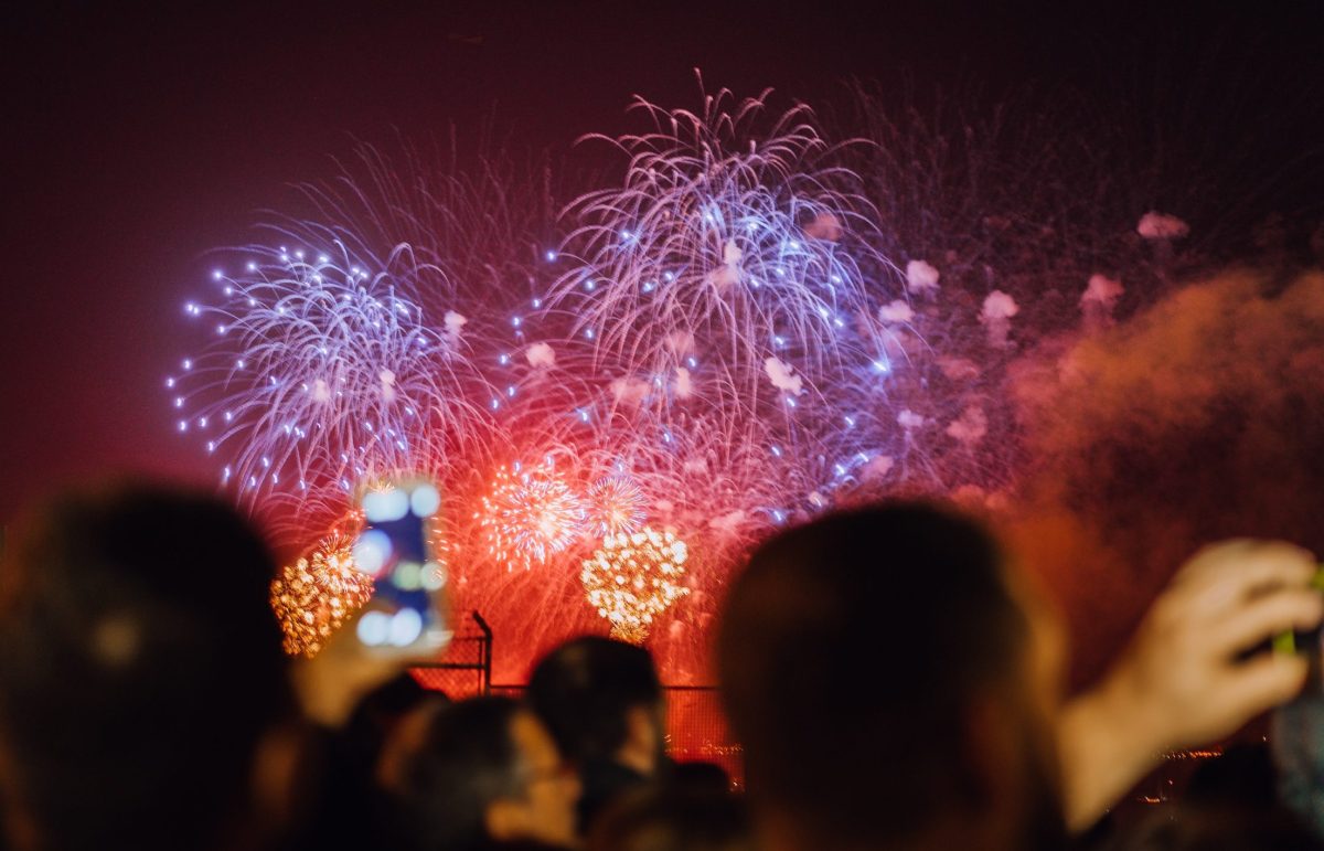 People in silhouette watch fireworks