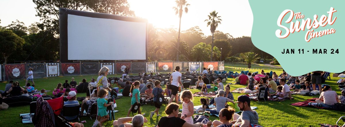 People settling into Wollongong Botanic Gardens for an outdoor film screen at sunset