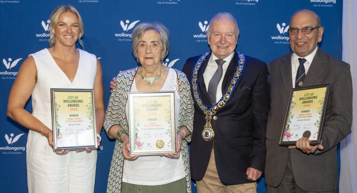 Three people holding community awards.