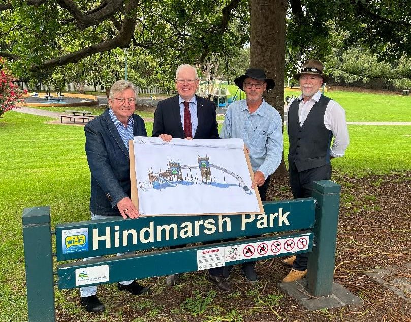 Four men hold plans for the park upgrade.