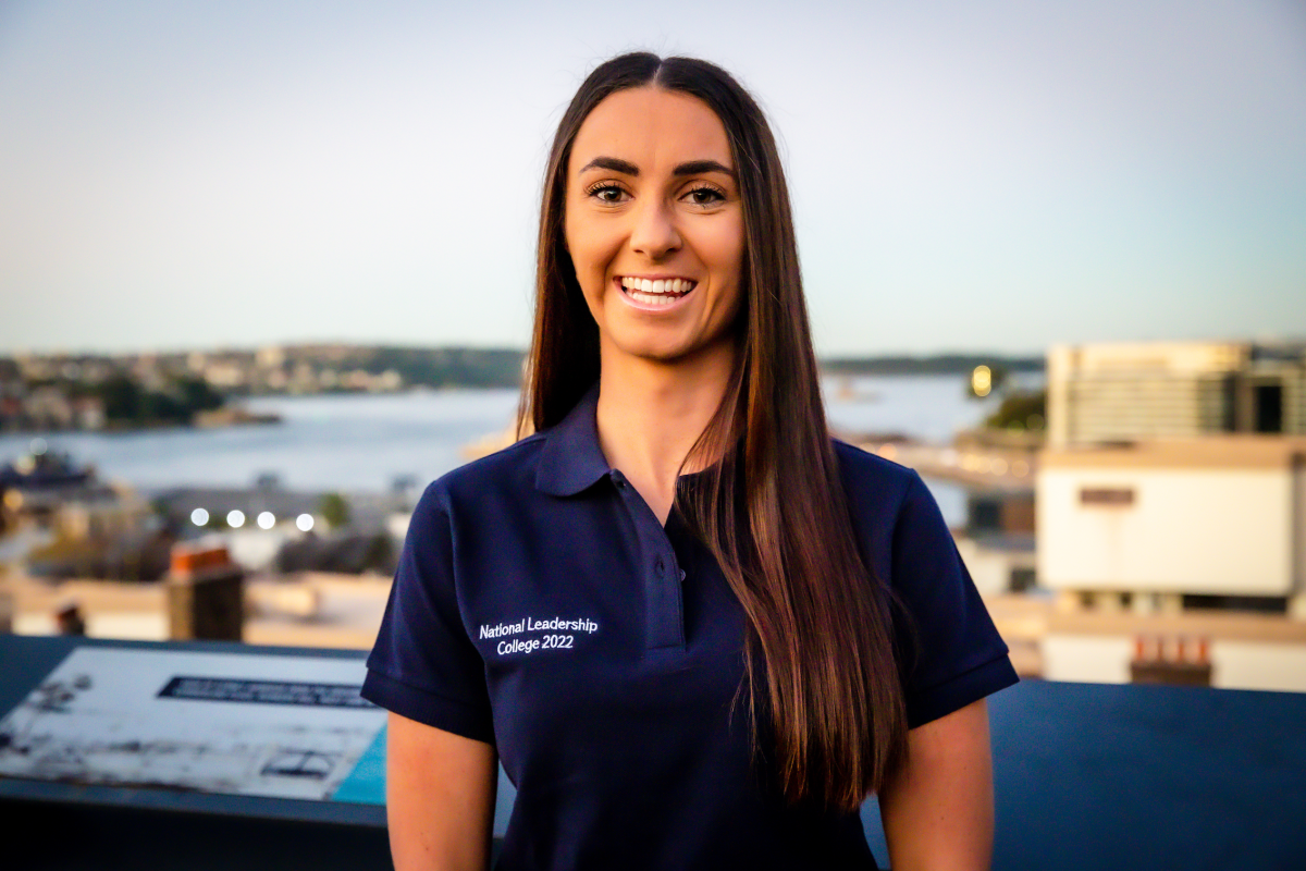 Wollongong Surf Lifesaver Shannon Fox stands on a rooftop with the bay in the background