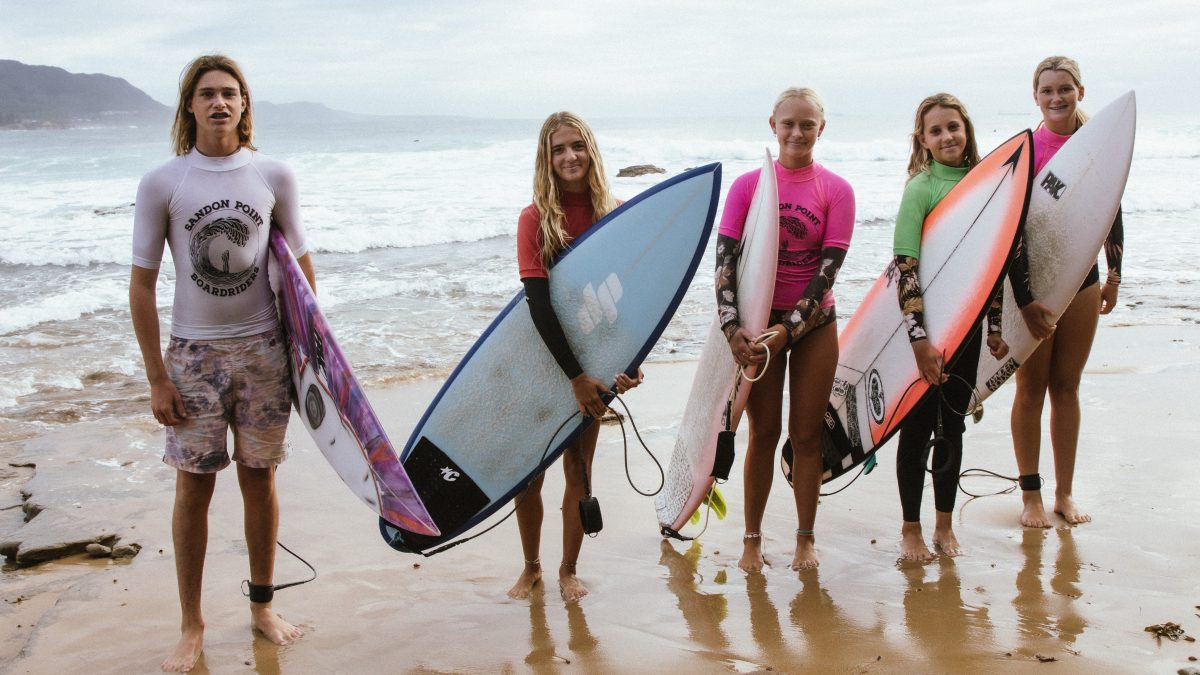 Five students with surfboards.