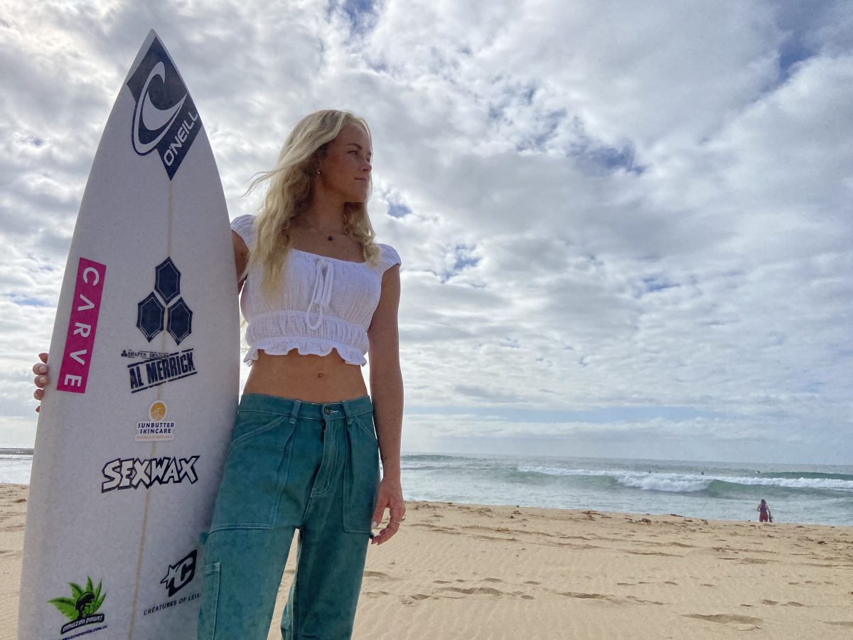 Young surfer Oceanna Rogers holds her board at Woonona Beach