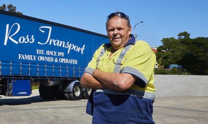 Man standing in front of large truck.