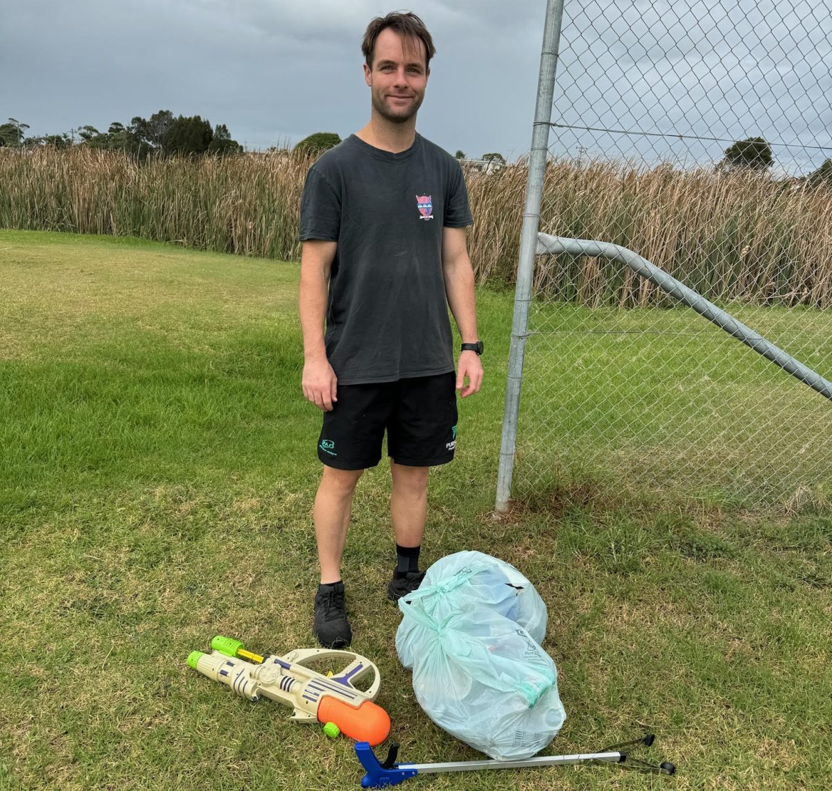 North Wollongong resident Sam Hodges stand next to a bag of rubbish he has collected