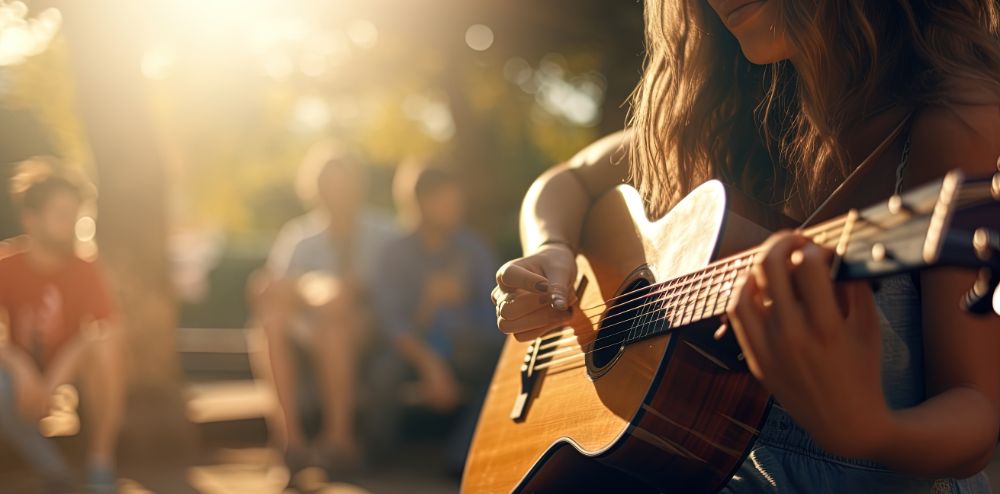 Detail of woman strumming guitar at sunset