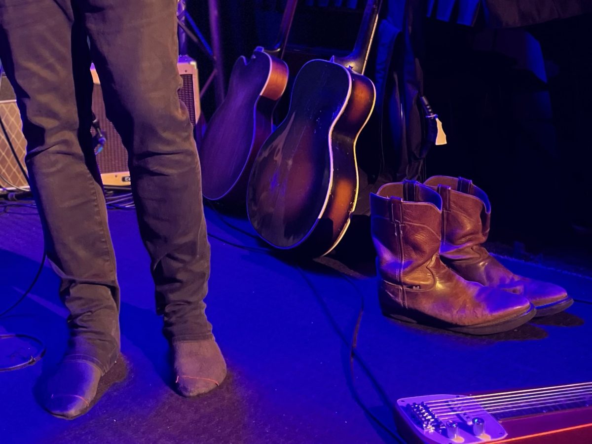 Man with his boots off on stage