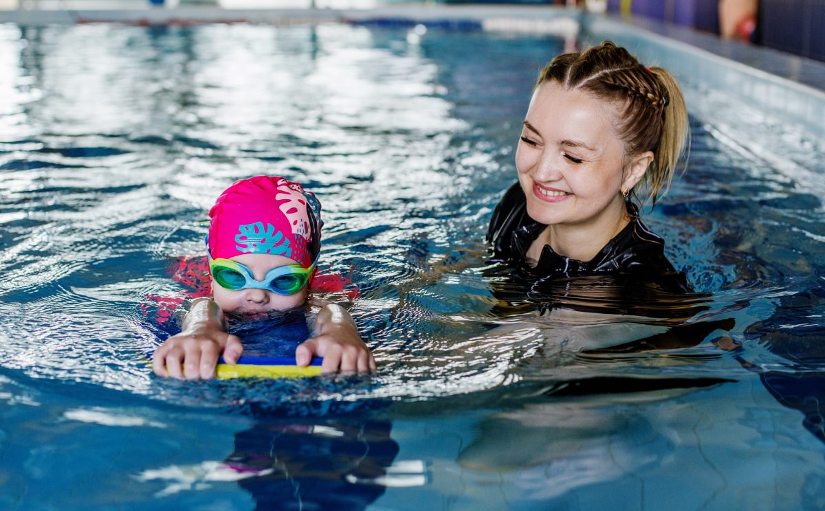 Kid in pool learning to swim.