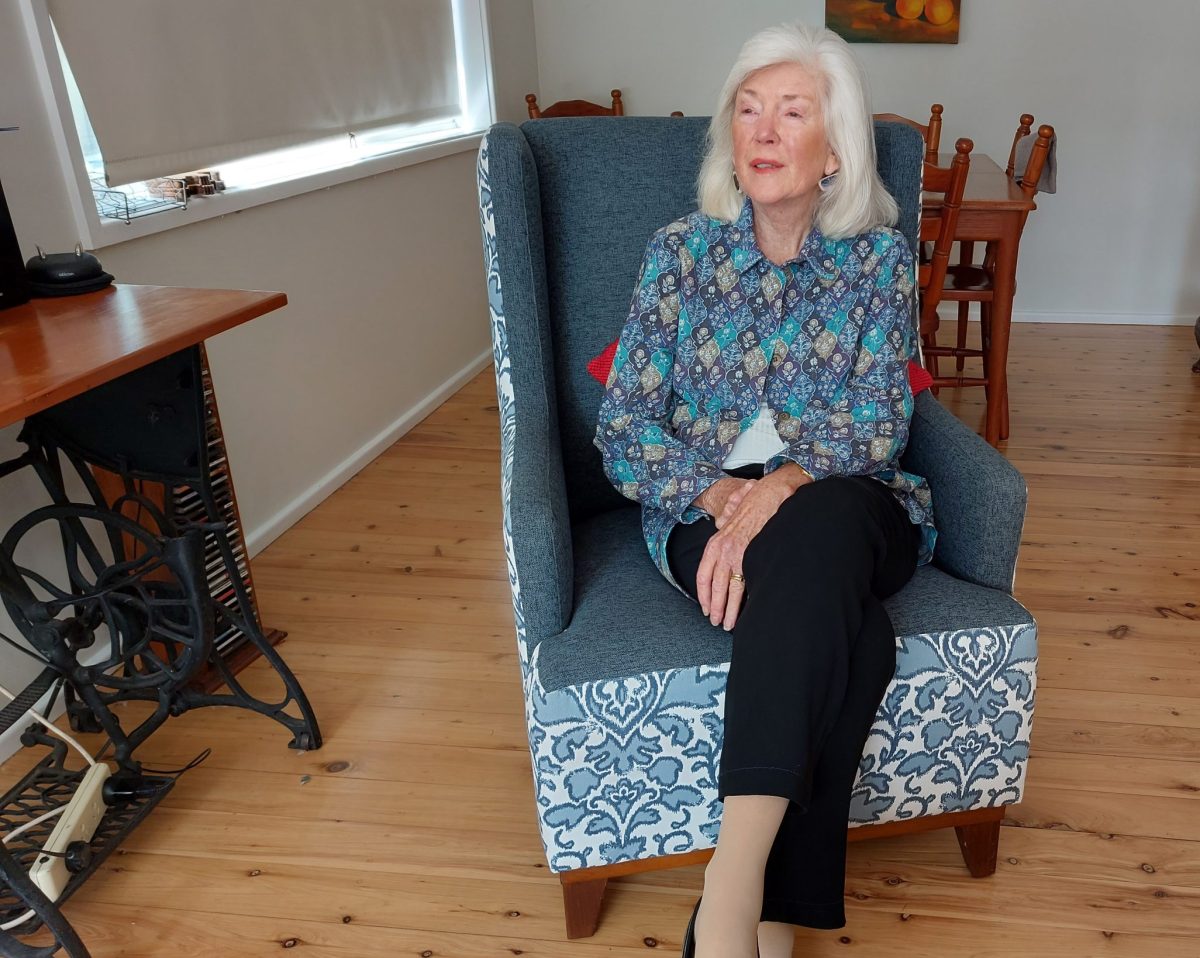 Woman sitting in a blue chair.