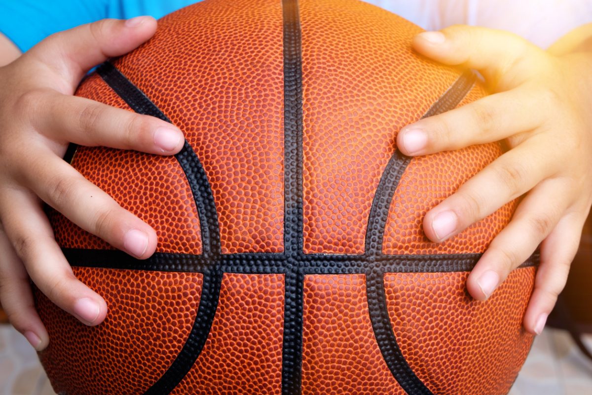 Close up of child's hands holding a basketball
